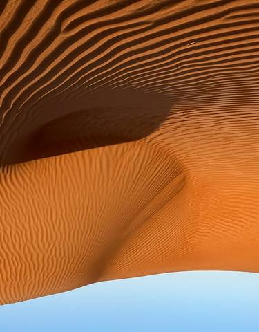 Golden sand dunes under a clear blue sky.