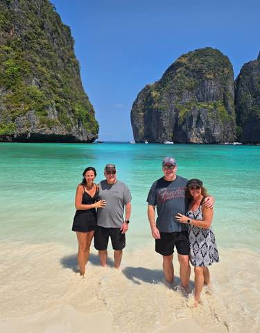Group of people standing on a tropical beach.