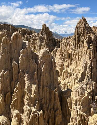 Eroded rock formations in a valley landscape.
