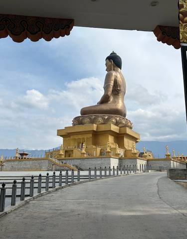 Large Buddha statue overlooking the landscape.