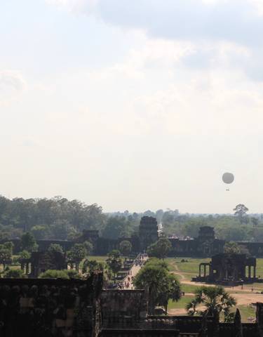 View of Angkor Wat with a hot air balloon in the sky.