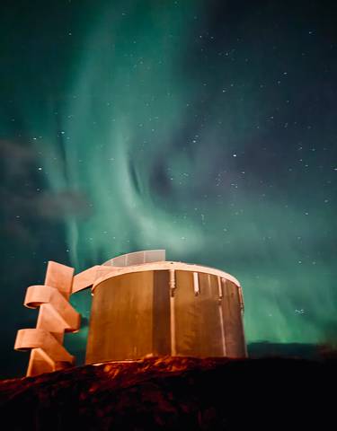 Northern lights over a futuristic building.