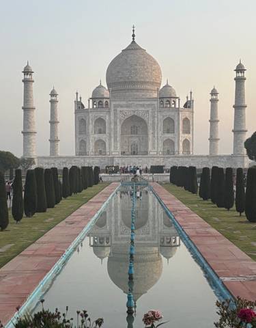 The Taj Mahal with a reflection pool and visitors.
