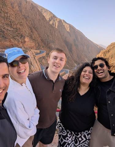 Group of friends smiling with a scenic mountainous backdrop.