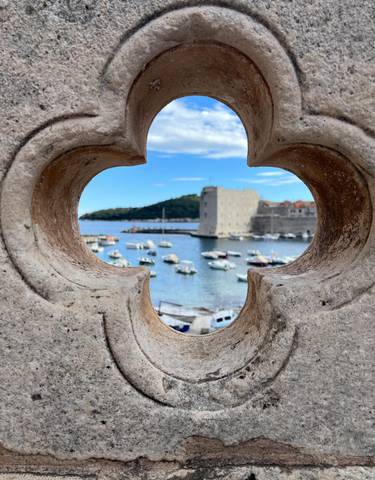 A scenic view of a bay through a carved stone frame.