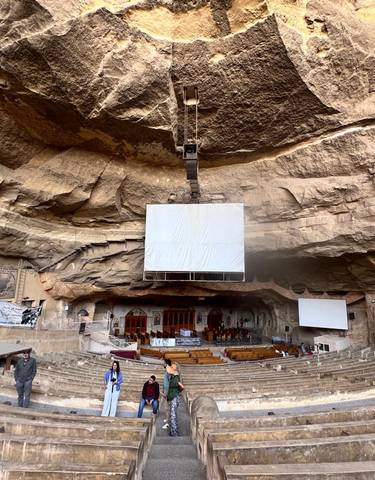 Large auditorium set inside an impressive rock formation.