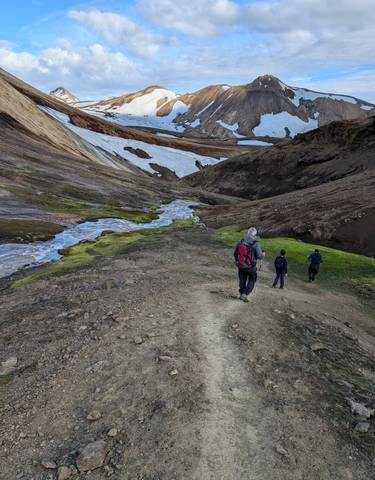 Hikers exploring a colorful volcanic landscape.