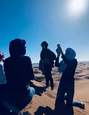 People exploring sand dunes in a desert.