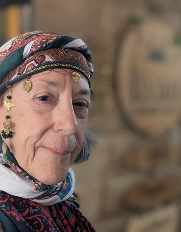 Woman in traditional Turkish attire with decorative coins and patterns.