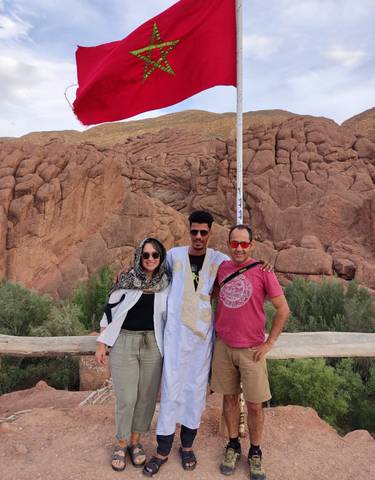 Three friends posing in front of a rocky landscape.