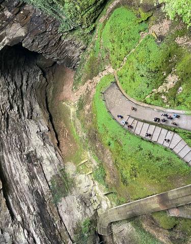 Overhead view of a large cave entrance with walkway.