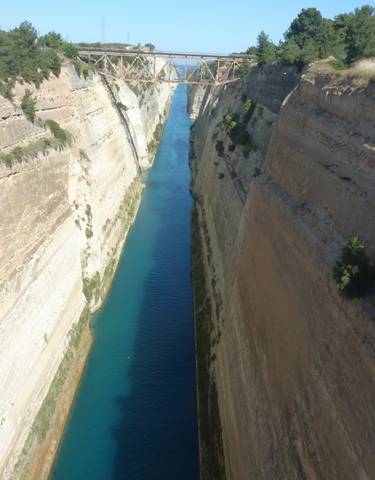 Deep canal flanked by rocky walls, spanned by a bridge.