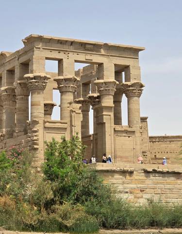 Ancient Egyptian temple with columns and tourists.