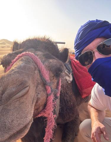 Person and camel in the Sahara Desert.