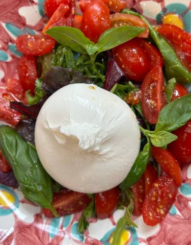 Caprese salad with mozzarella and tomatoes on a colorful plate.