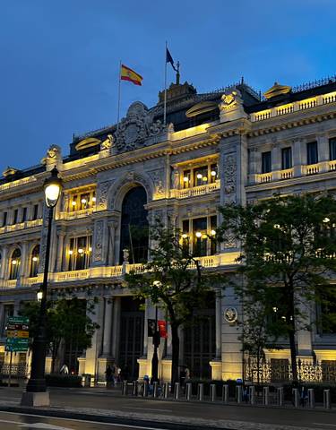 An illuminated historic building in an urban setting at night.