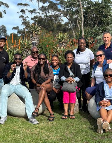 Group of people sitting in a garden setting.
