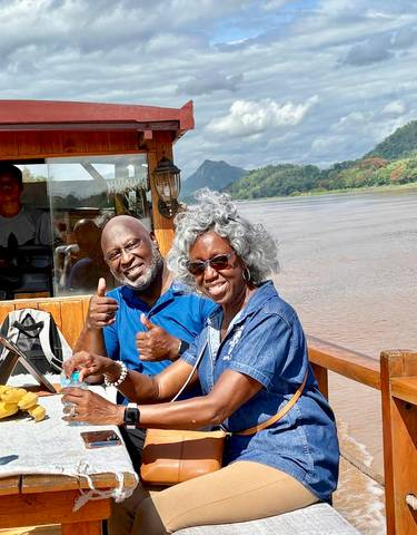 Couple enjoying a ride on a boat along a river.