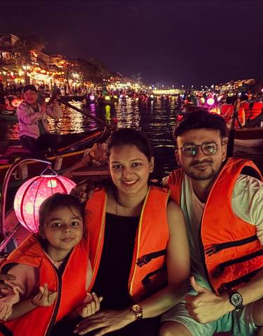 Family on a boat during a night lantern festival.
