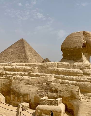 Sphinx and Pyramid of Giza against a clear sky.