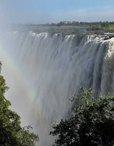 Victoria Falls with a rainbow over the waterfall.