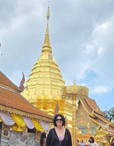 A golden temple with intricate architecture against the blue sky.