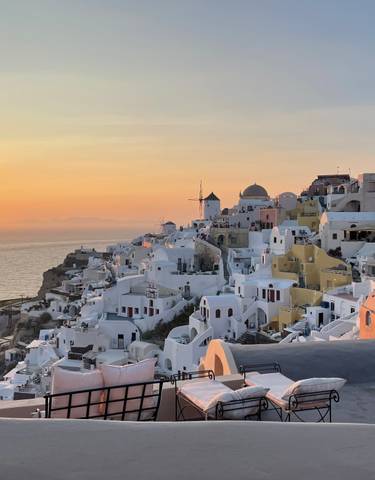 Sunset view of Santorini with white buildings and the sea.
