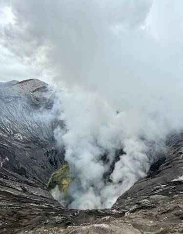 Volcanic crater emitting steam and gases.