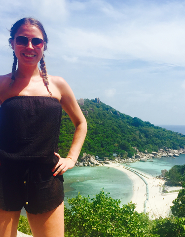 Person posing with a scenic island view in the background.