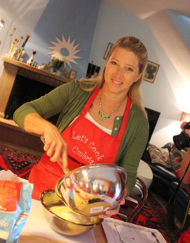 Woman smiling while cooking in a kitchen.