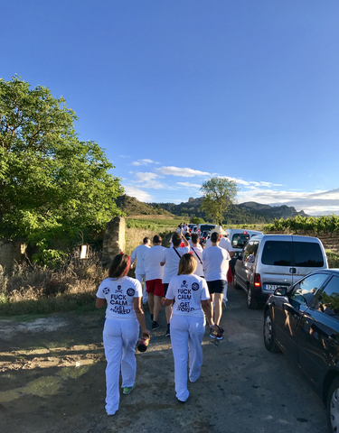 People running on a rural road with a backdrop of rolling hills.