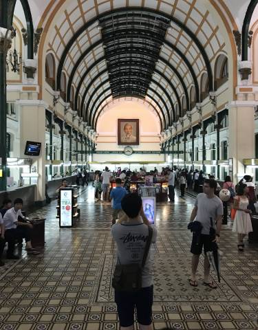 Interior of a busy post office with high ceilings.