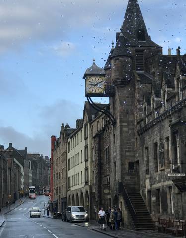 Historic clock on a building in a city street.