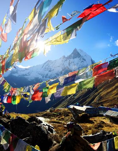 Colorful prayer flags with a mountain view.