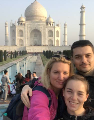People posing with the Taj Mahal in the background.