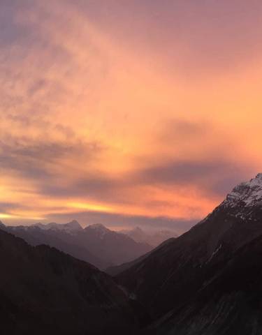 A vibrant sunset illuminating snow-covered mountain peaks.