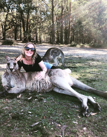 Person with a kangaroo in a park setting.