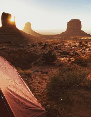 Sunset view of Monument Valley with a tent.