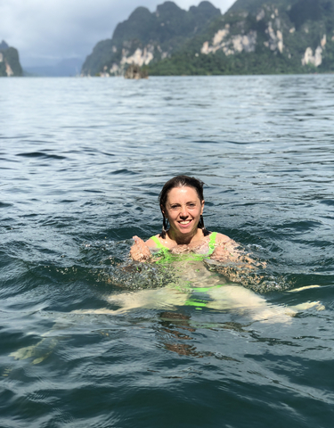 Smiling woman swimming in water.