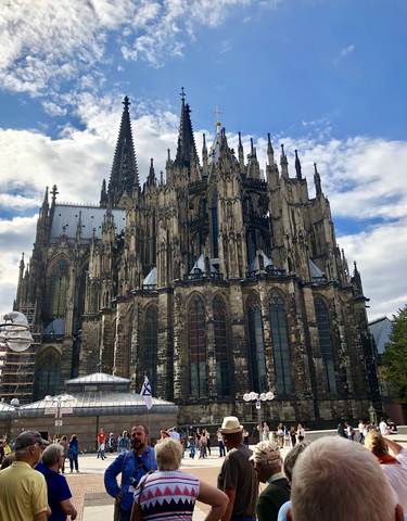 Gothic cathedral with intricate architecture under a cloudy sky.