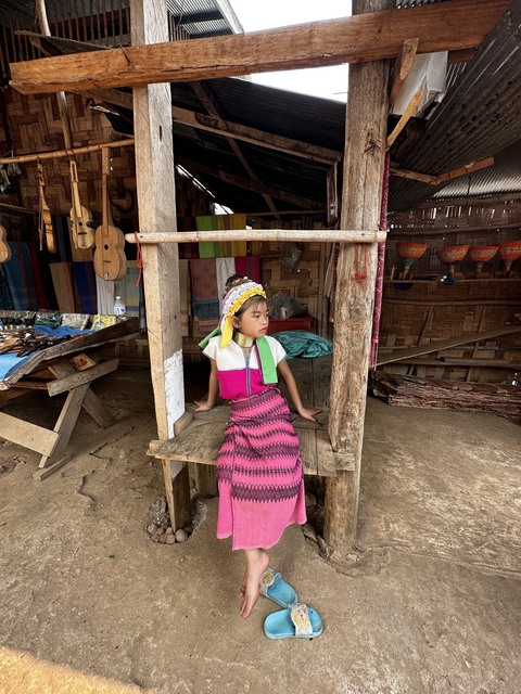 A child sitting in a traditional setting with crafts.