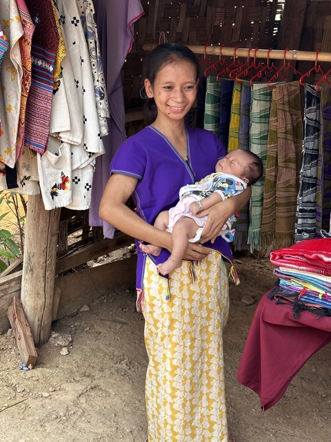 Woman holding a baby in traditional attire.