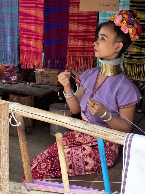 Woman weaving traditional fabric with colorful threads.