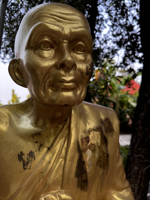 Close-up of a golden statue's face.