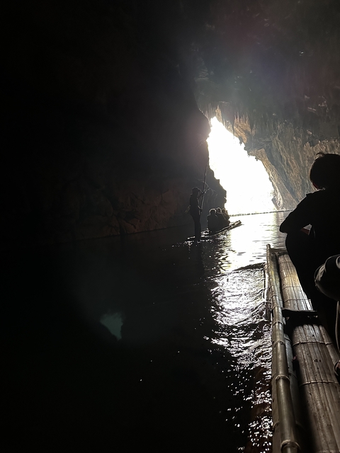 People on a raft inside a dark cave.