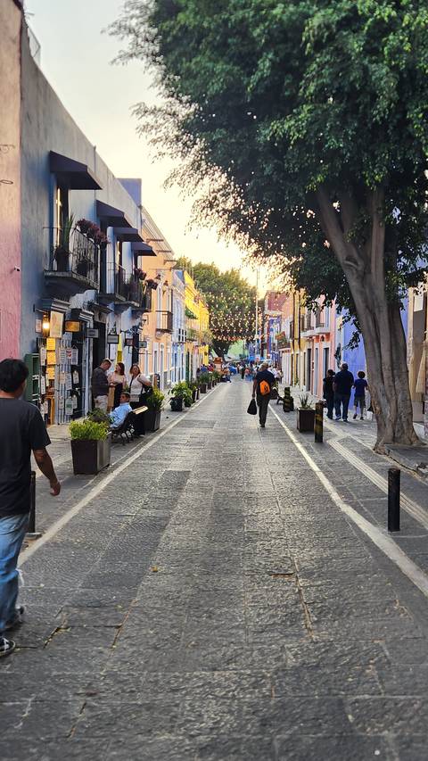 Street scene with people walking along colorful buildings.