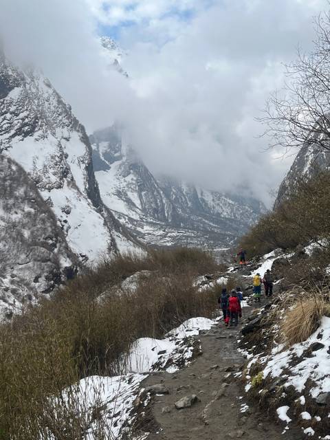Group trekking through a snowy mountain trail.