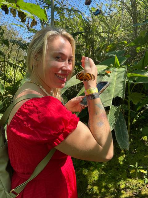A person with butterflies and greenery.