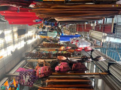 Indoor market scene with various goods displayed.