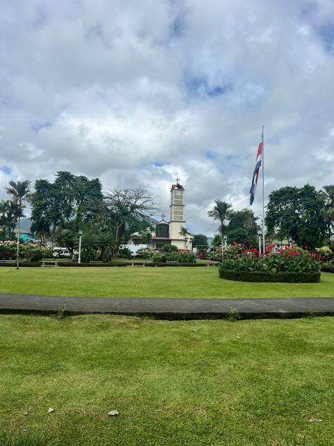 A monument with a flag and landscaped gardens.